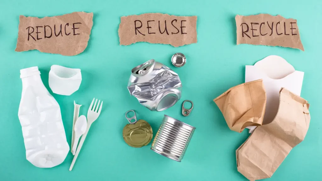 Reduce showing plastic bottles and cutlery, reuse showing steel and aluminum tins and recycle showing paper bags